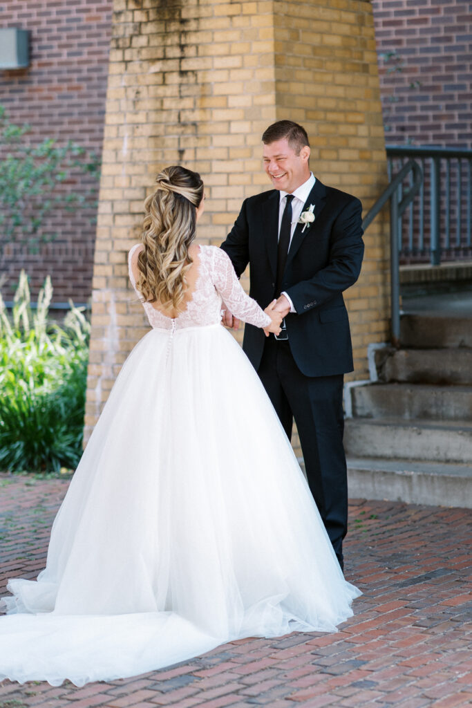 The groom’s eyes widen in awe as he sees his bride in her wedding dress for the very first time.