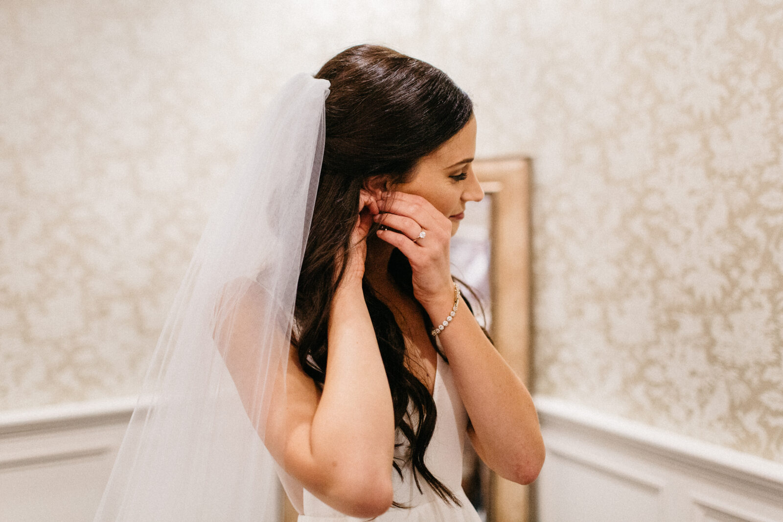 Bride putting on her earings at Bearpath Golf and Country Club