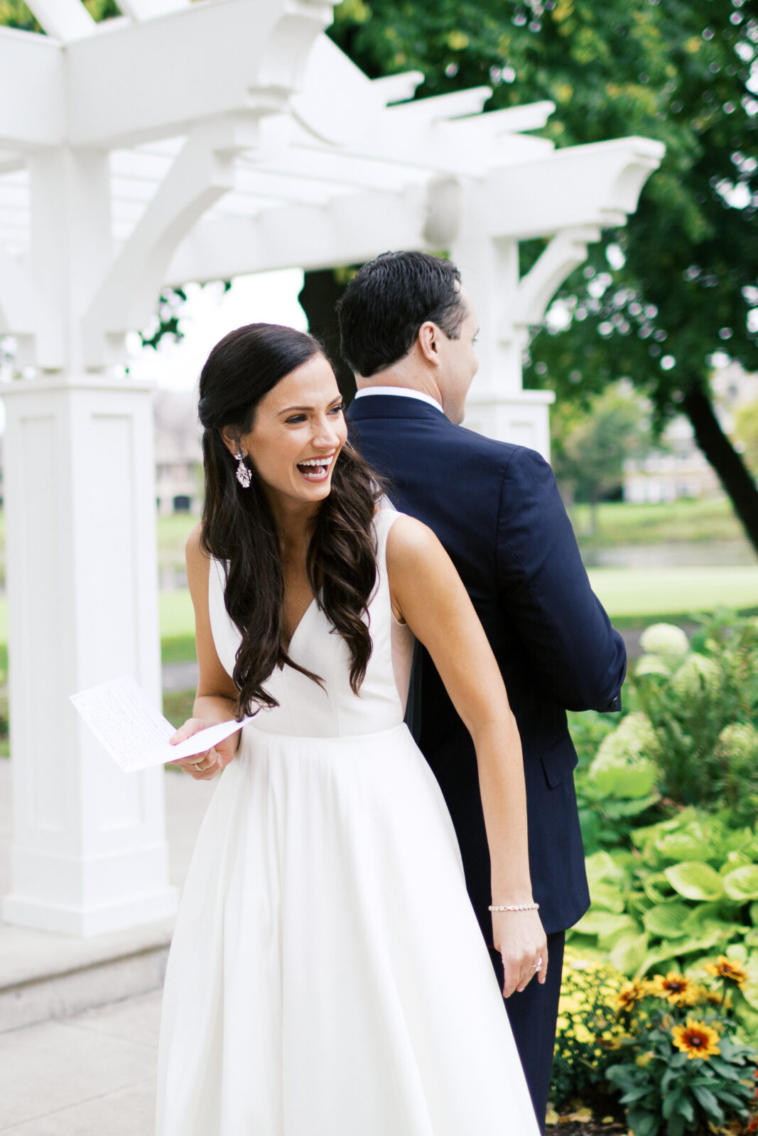 The bride is reading her vows to him in laughter.