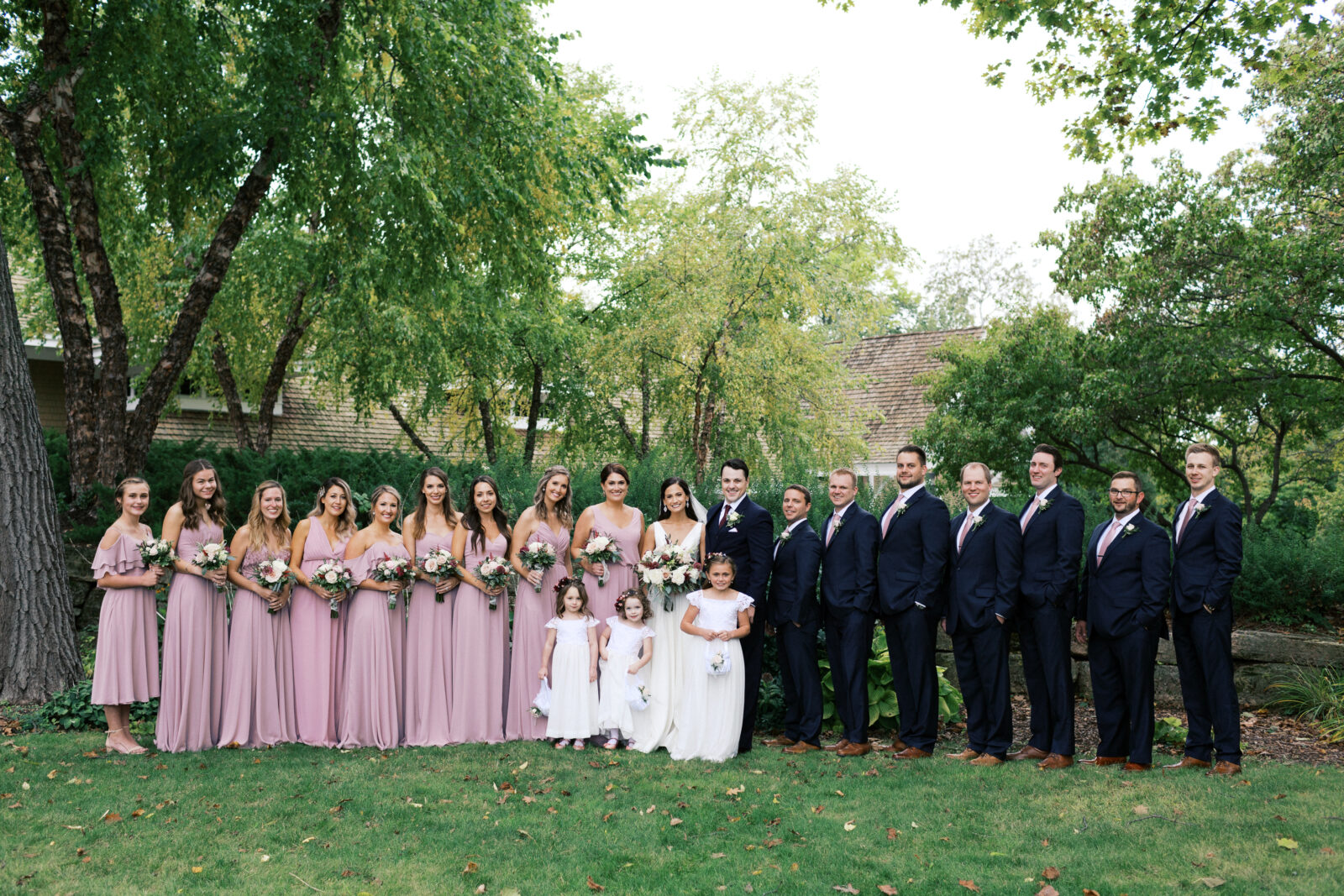 This is a wedding party group photo. Everyone is smiling and looking into the camera. The photo was taken at the Bearpath Golf & Country Club.