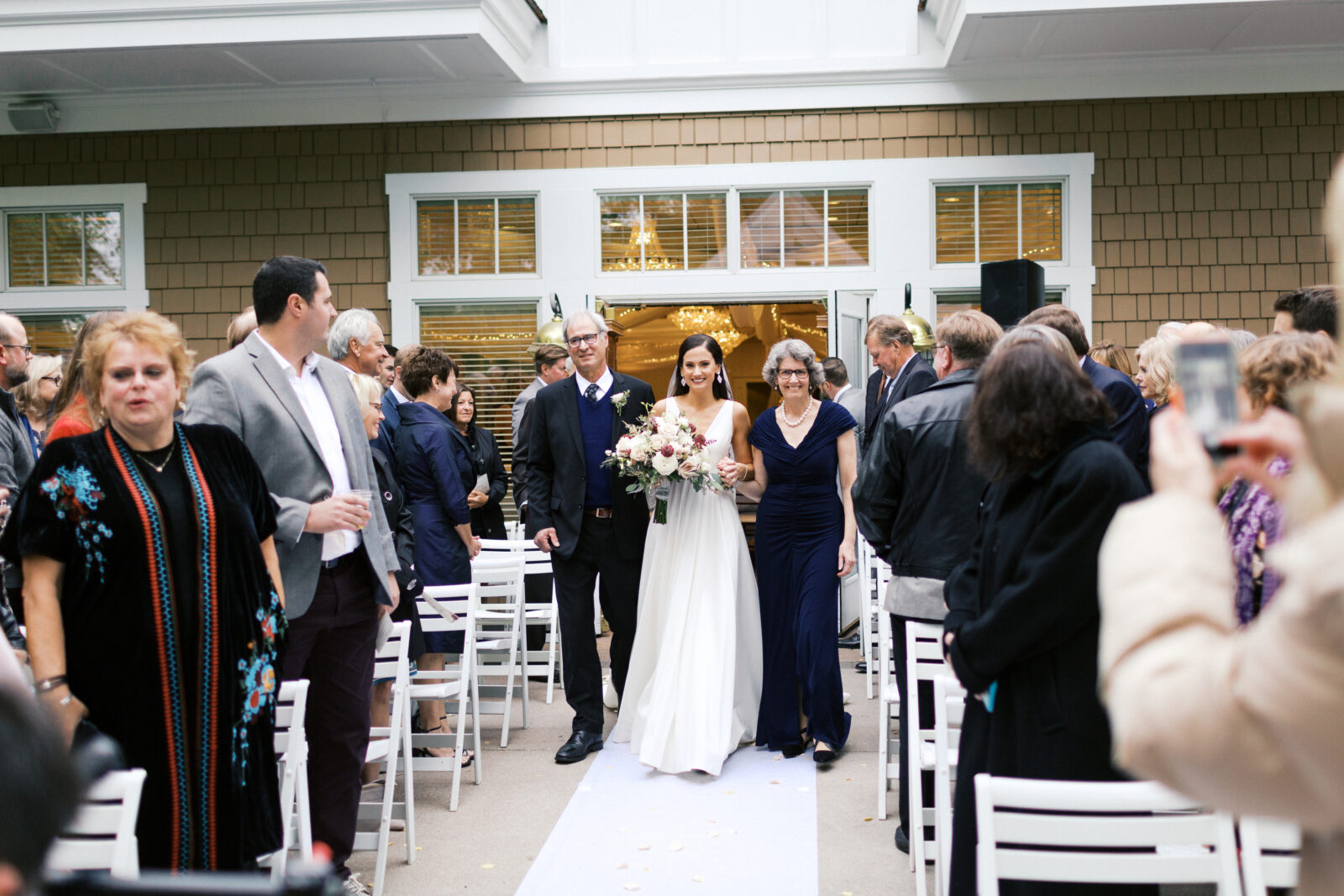 At the ceremony at Bearpath Golf and Country Club, the bride's parents walked her down the aisle with smiles on their faces. 