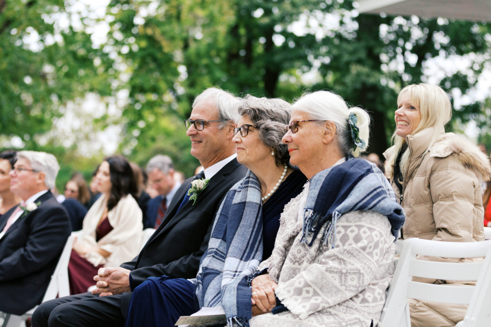 Parents of the bride with joy sitting at the ceremony to witness their vows. 