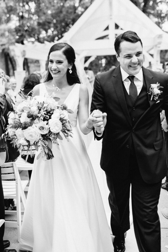 A newly married couple makes a grand exit down the aisle at Bearpath Golf & Country Club. They look so happy and joyful.