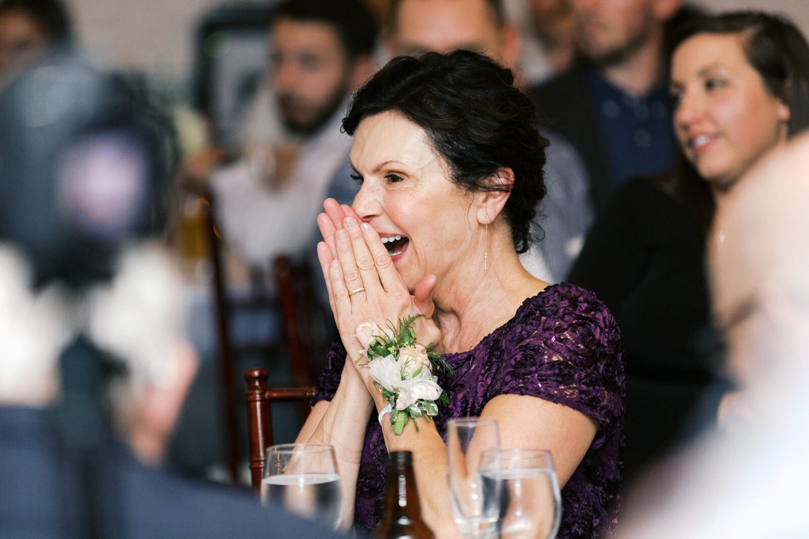 A mother's excitement for her daughter's wedding is evident in this photo. She is beaming with joy and anticipation.