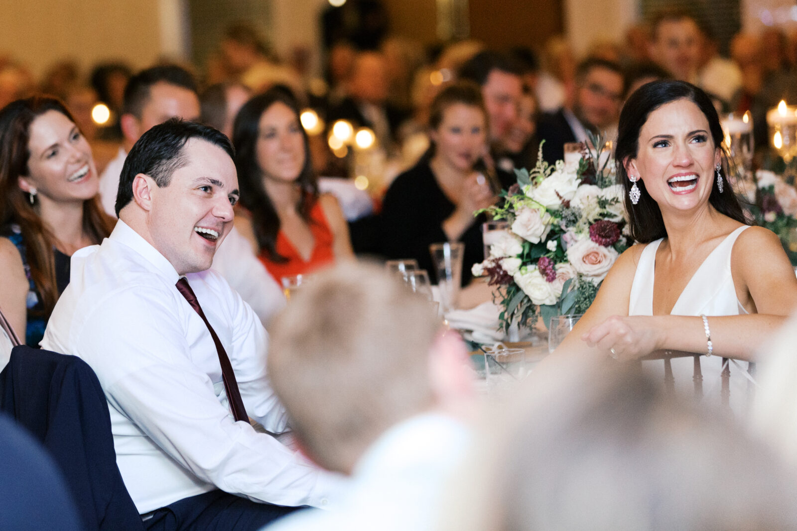 The bride and groom listen to speeches from loved ones with excitement and a lot of emotion. Bearpath Golf and Country Club in Eden Prairie. 
