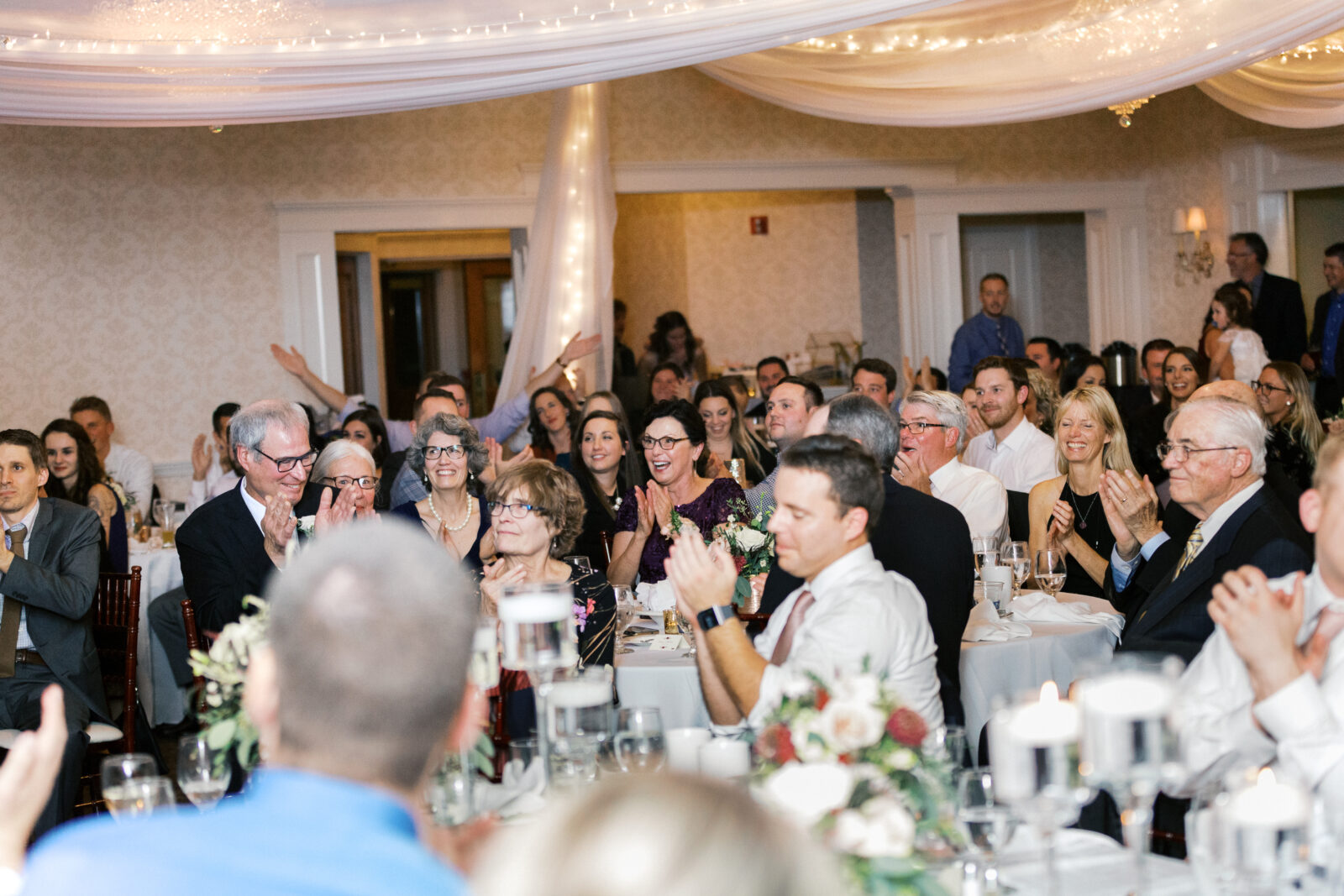 Guests are celebrating at a wedding reception. 