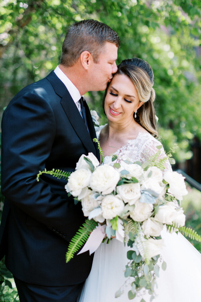 Portrait of bride and groom kissing her head. Photographer by Toly Dzyuba Photography.