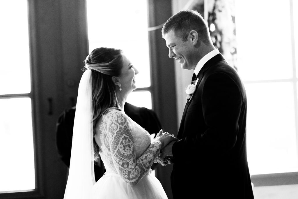 Bride and groom looking at each other with joy on their ceremony. 