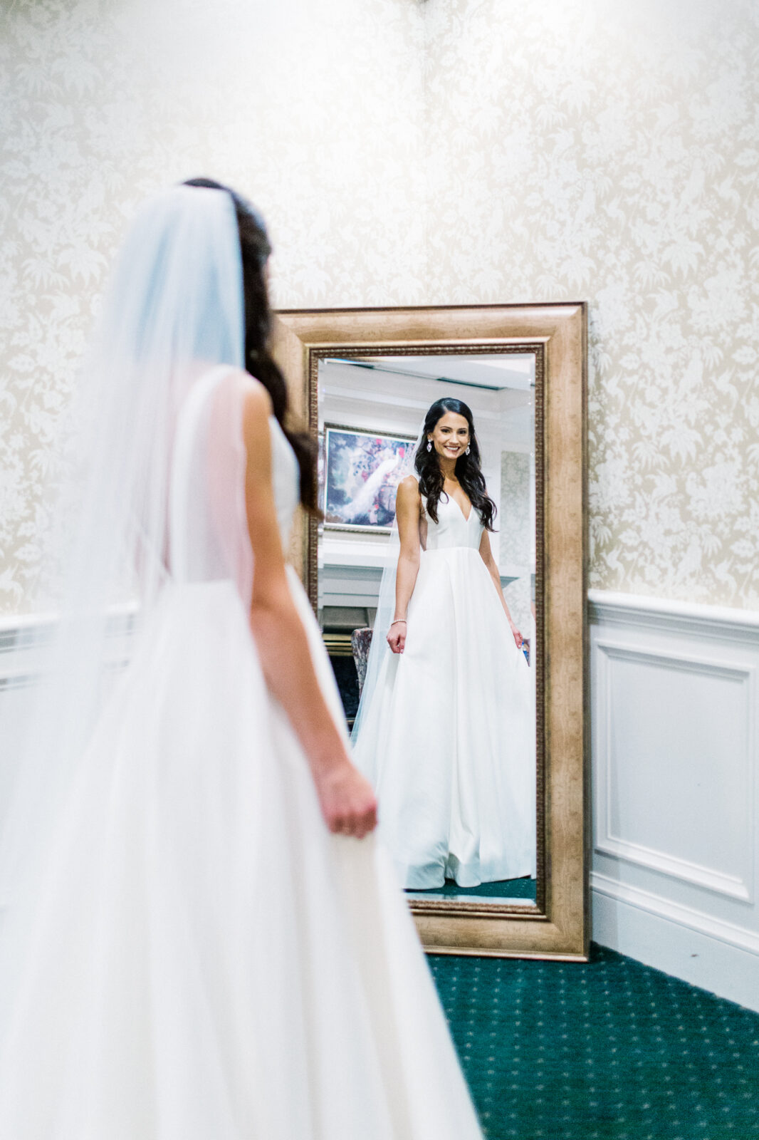 Bride is looking at herself in the mirror before she sees her groom at Bearpath Golf and Country Club