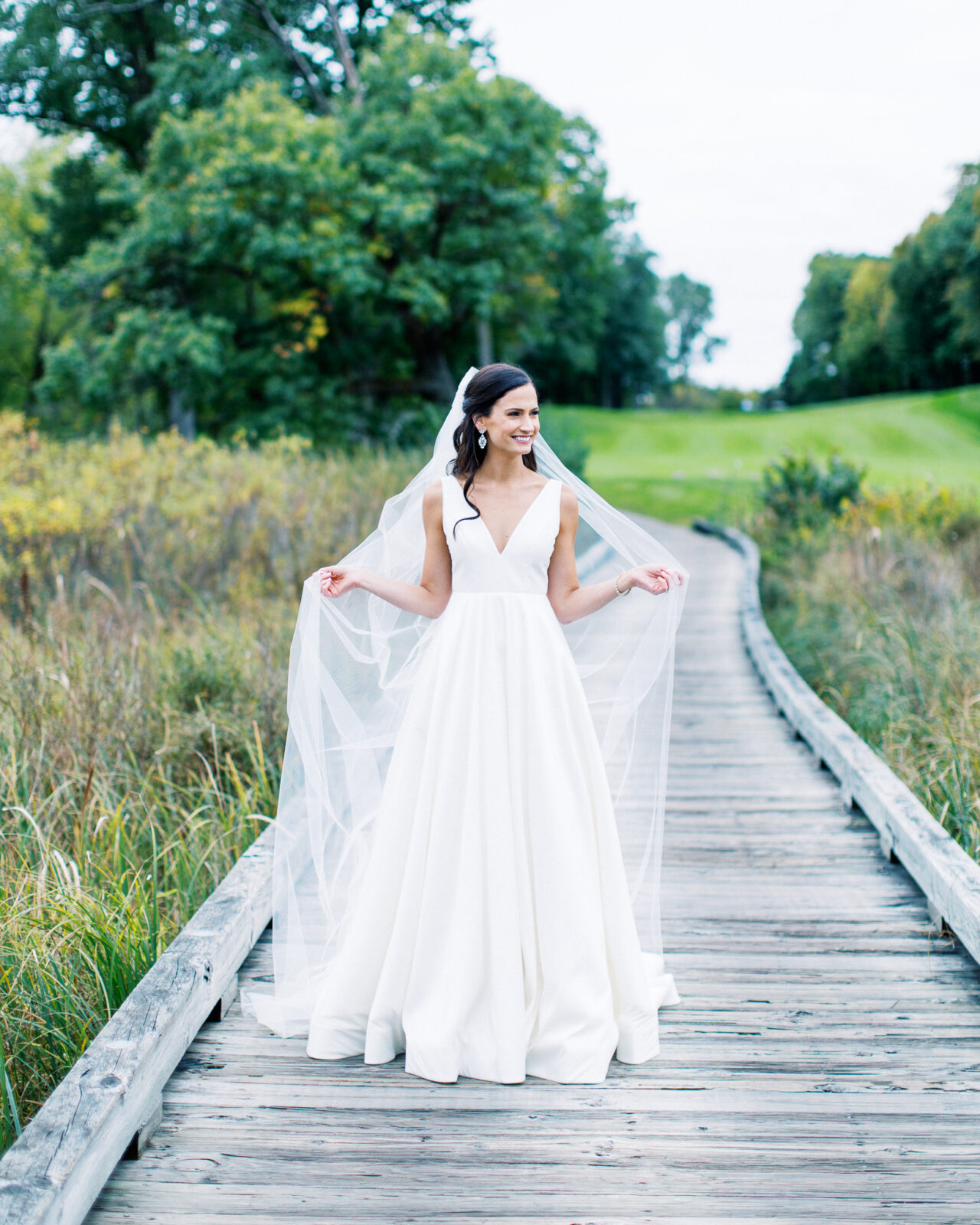 The bride is showing of her vail while Minnesota wedding photographer is capturing the moment