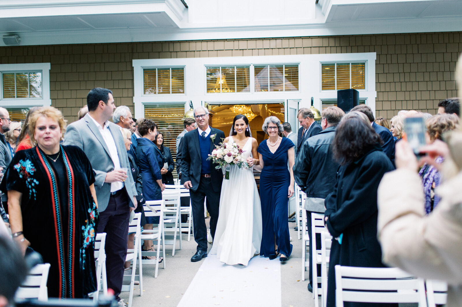 Parents at the ceremony walking down their daughter 