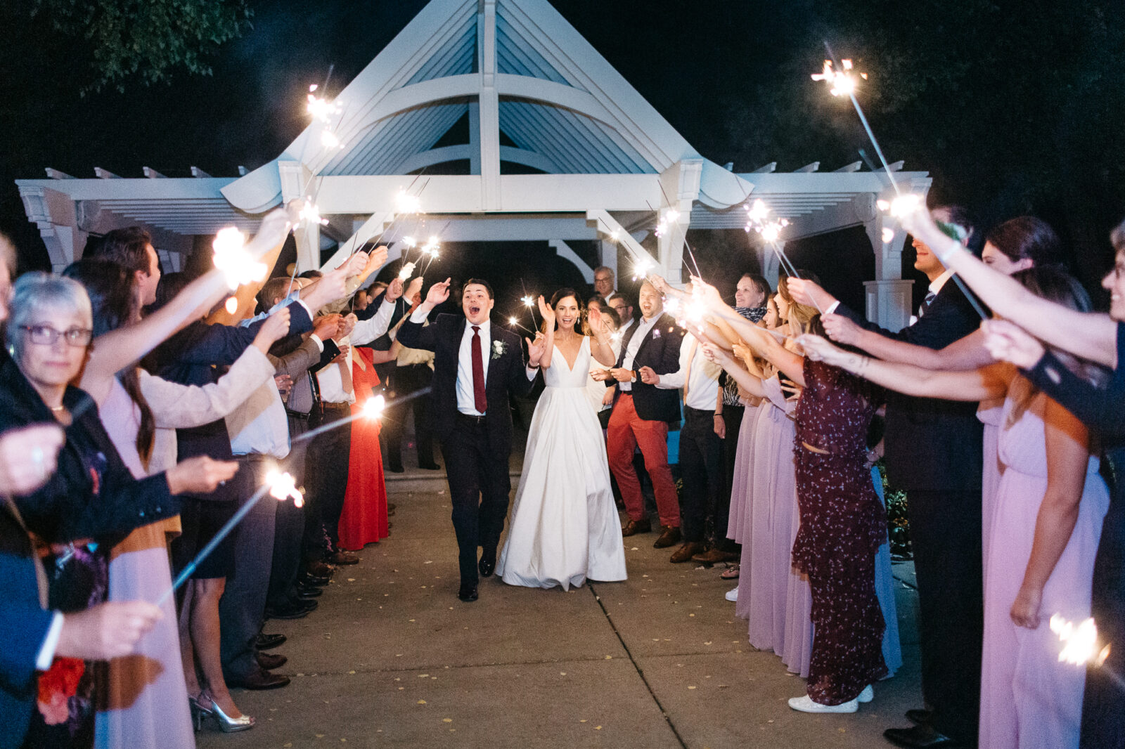 Bride and groom walking out with sparklers