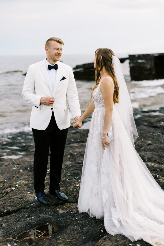 Husband and wife are looking at each other smiling with the sound of water on the background. Bluefin Bay Resort, North Shore.