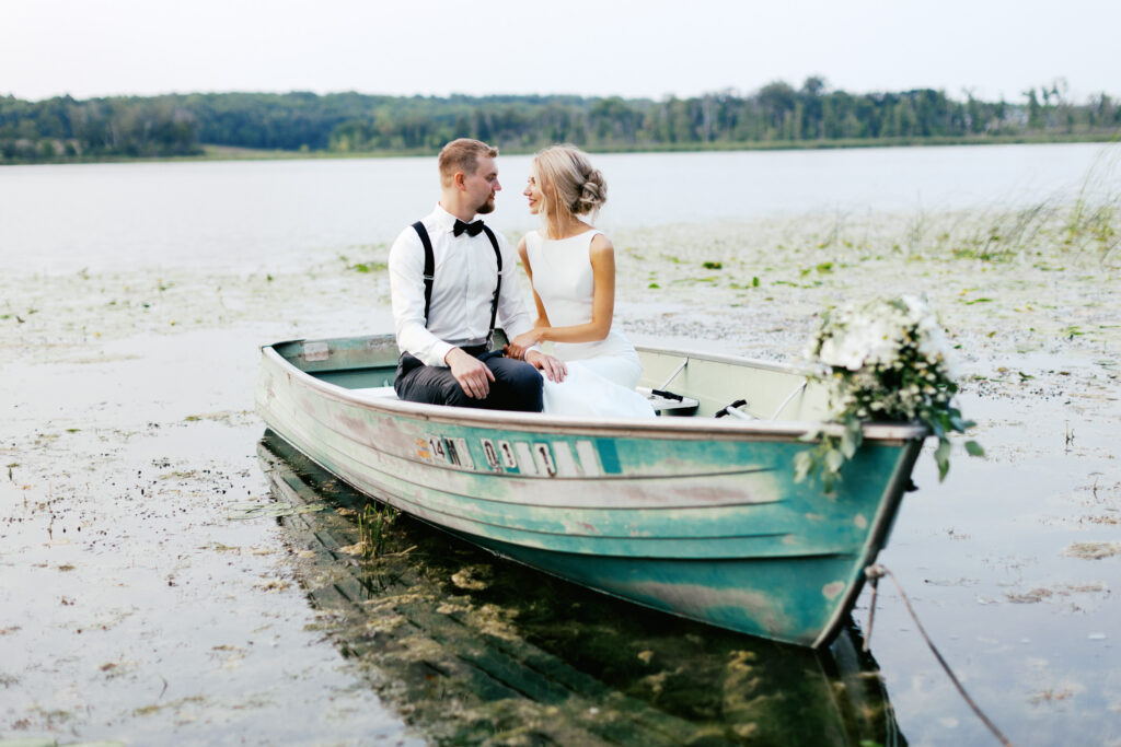 Minnesota wedding photographer captures Bride and groom in the boat looking at each other with joy.