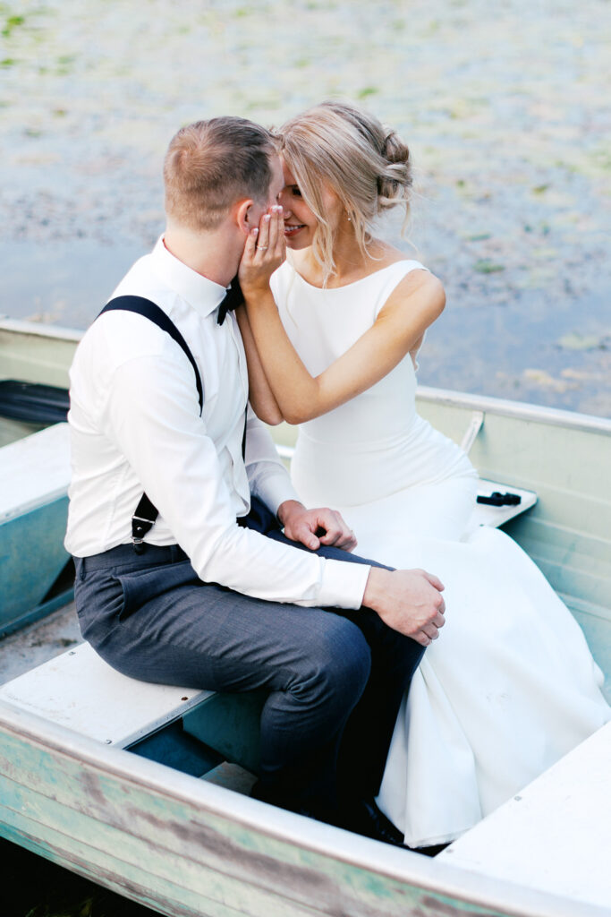 Bride and Groom touching foreheads in the boat of Detroit Lakes in Minnesota