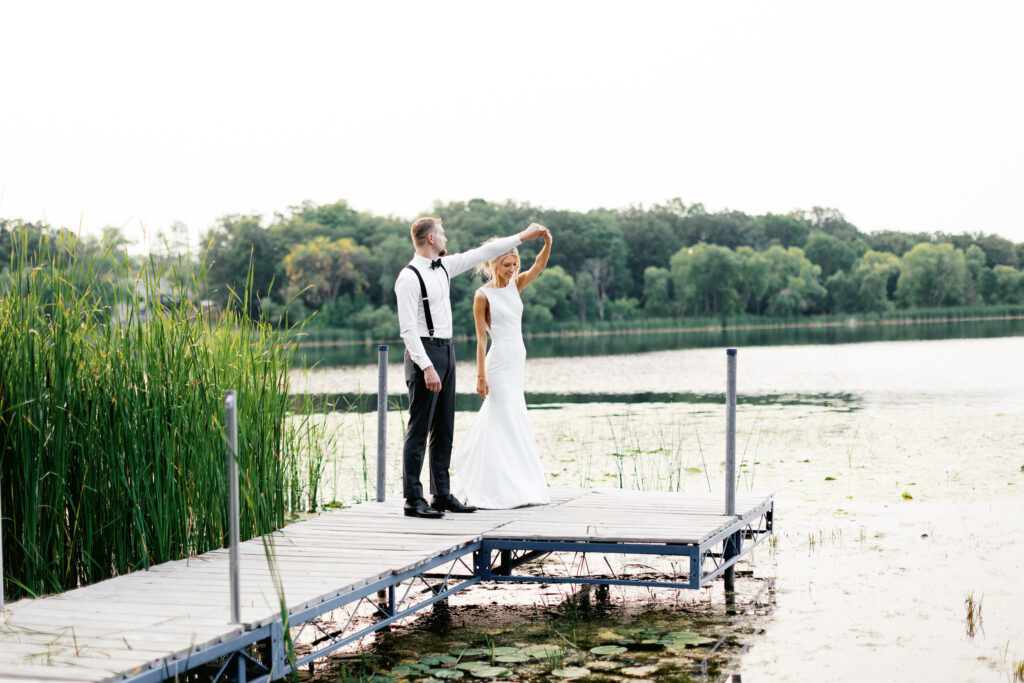 Bride and groom dancing on the dock with a sunset.