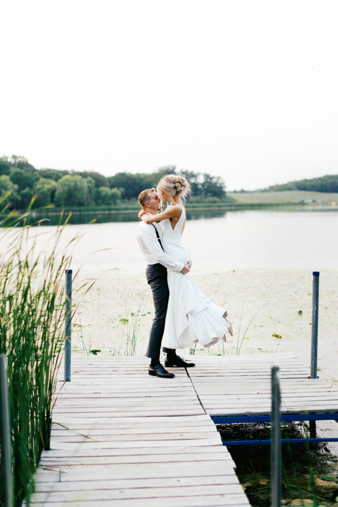 Scene straight out of a fairytale Bride and groom creating Magic on the lake dancing.