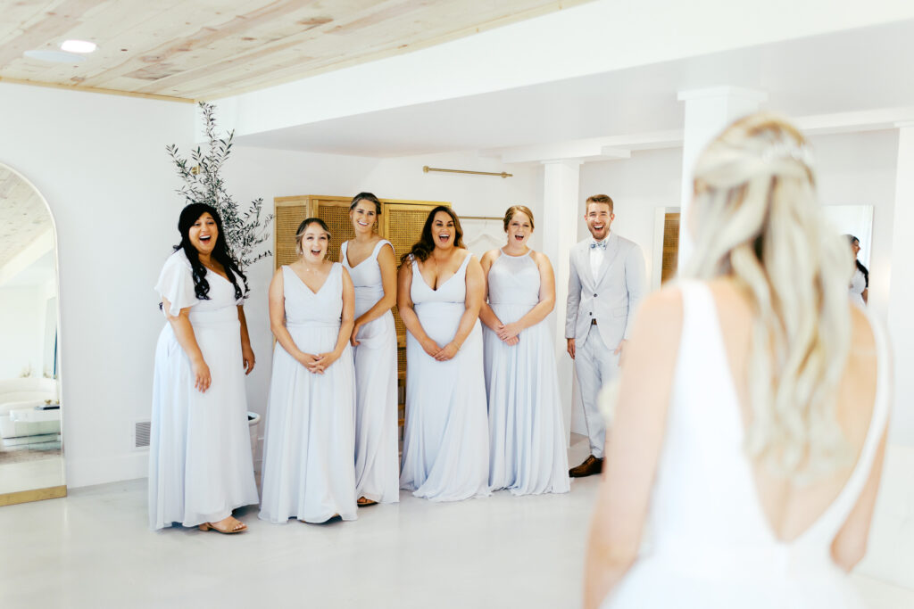 Bridesmaids are in awe when seeing the bride for the first time in her dress at Ivory North Co