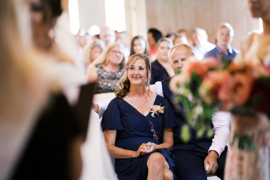 Mother of the bride sitting listening the vows at Abella Weddings and Events Ceremony barn,
