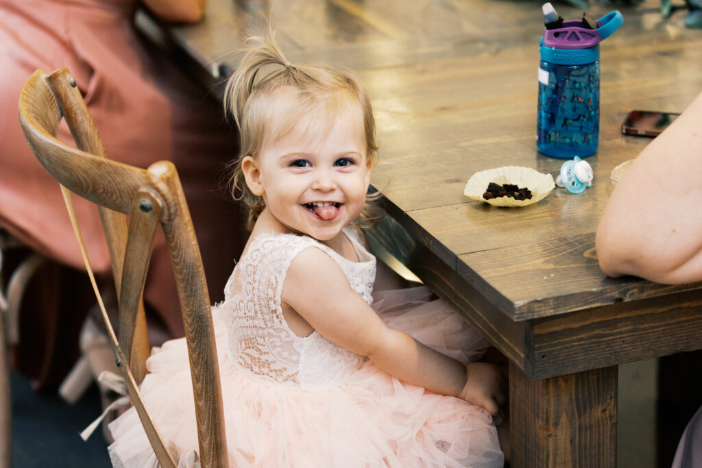 Flower girl smiling at the cameraman. 