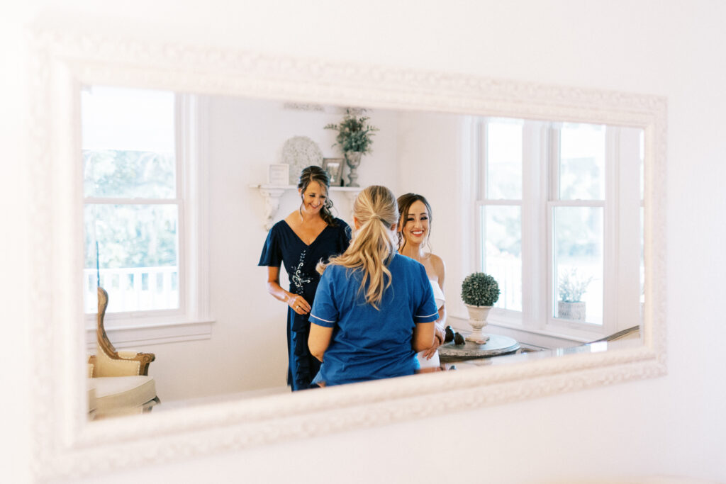Mother helping her daughter on her wedding day with her dress at Abella Weddings & Events venue in Minnesota.