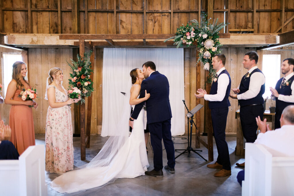 Wedding ceremony, newlyweds sharing their first kiss in the bar at Abella Weddings and Events, captured by Minnesota wedding photographer.
