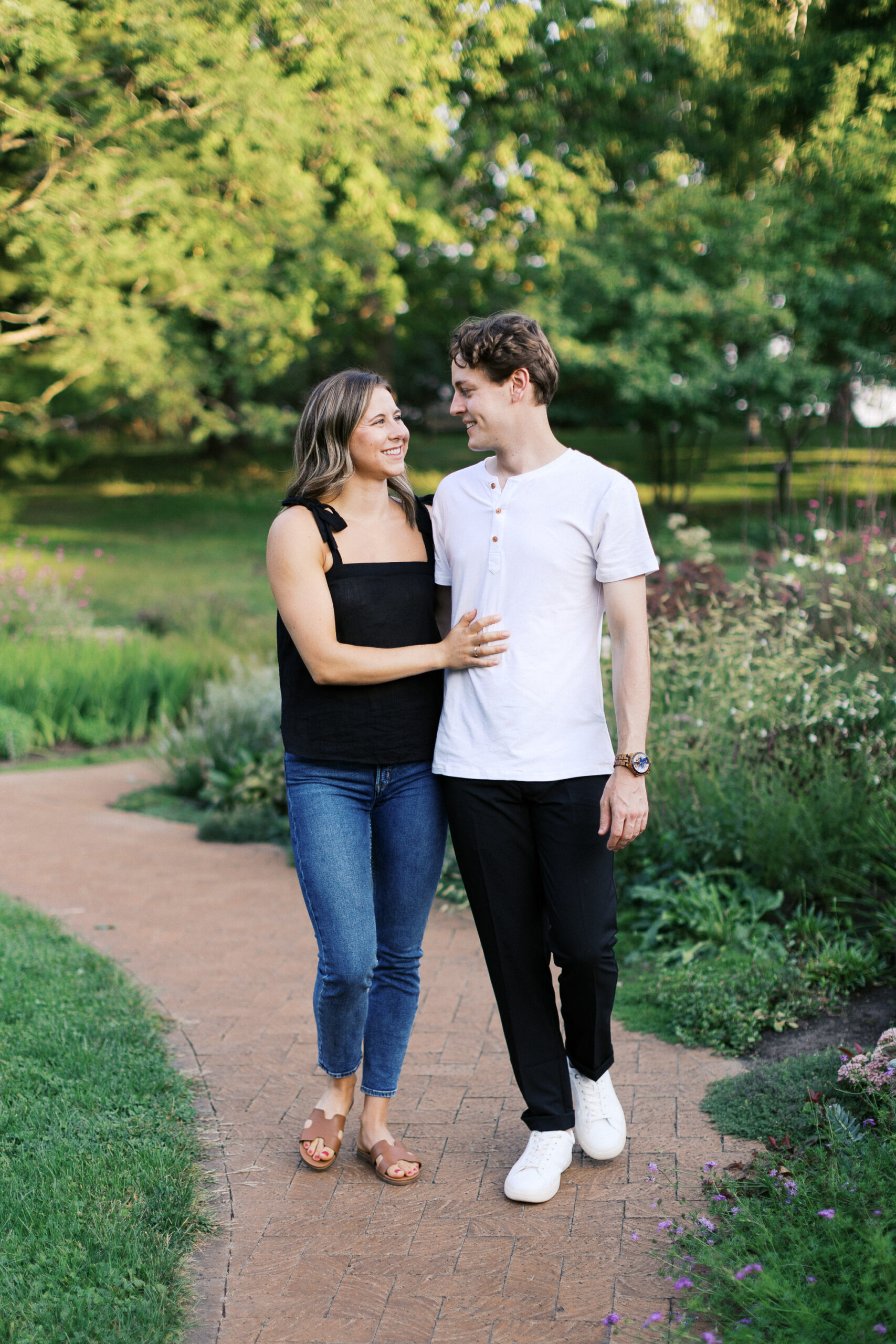 The couple walks through the gardens, smiling at each other, radiating love and happiness. Captured by Toly Dzyuba Photography.