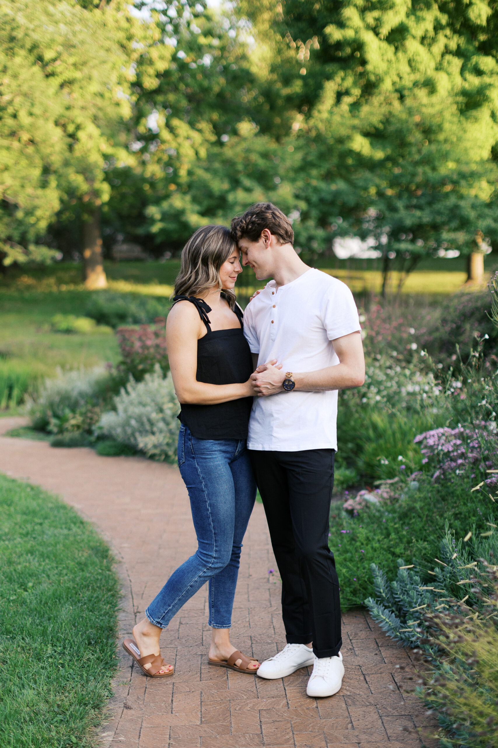 With eyes closed, the couple shares a tender moment, holding hands and gently touching foreheads at Noerenberg Gardens. Captured by Toly Dzyuba Photography.