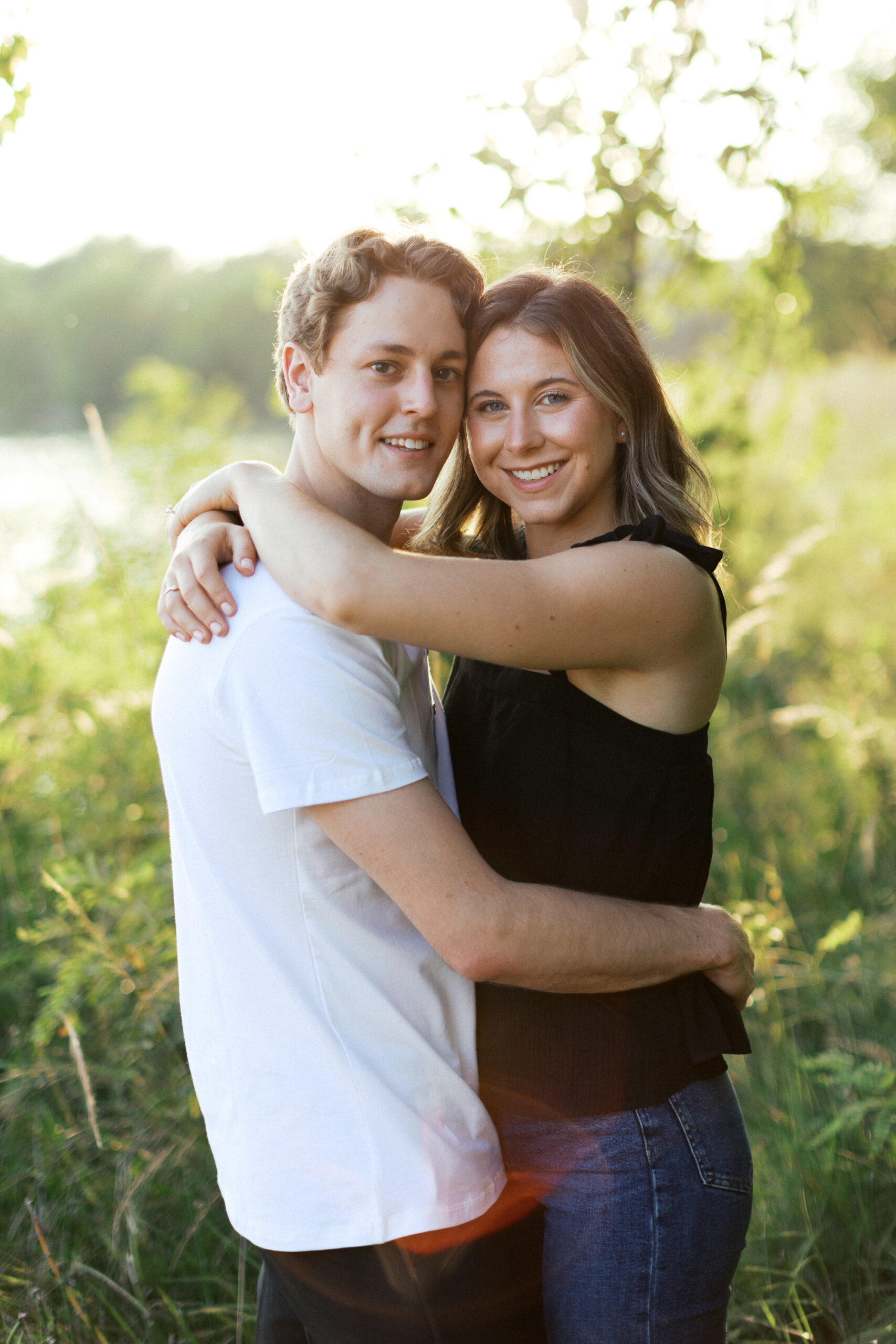 A heartfelt hug as the couple embraces, looking into the camera with smiles full of love. Captured by Toly Dzyuba Photography.