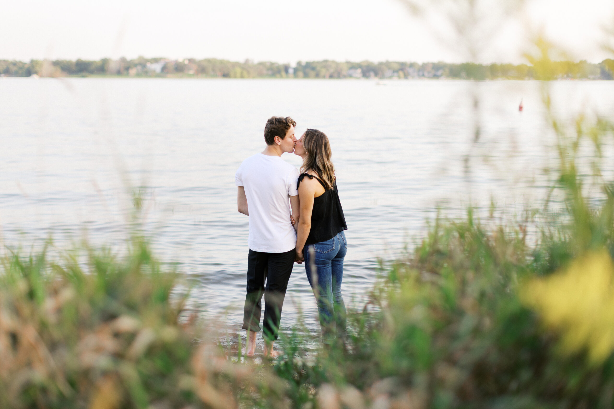 A romantic kiss as the couple stands barefoot in the lake, their love captured in a beautiful moment. Captured by Toly Dzyuba Photography.