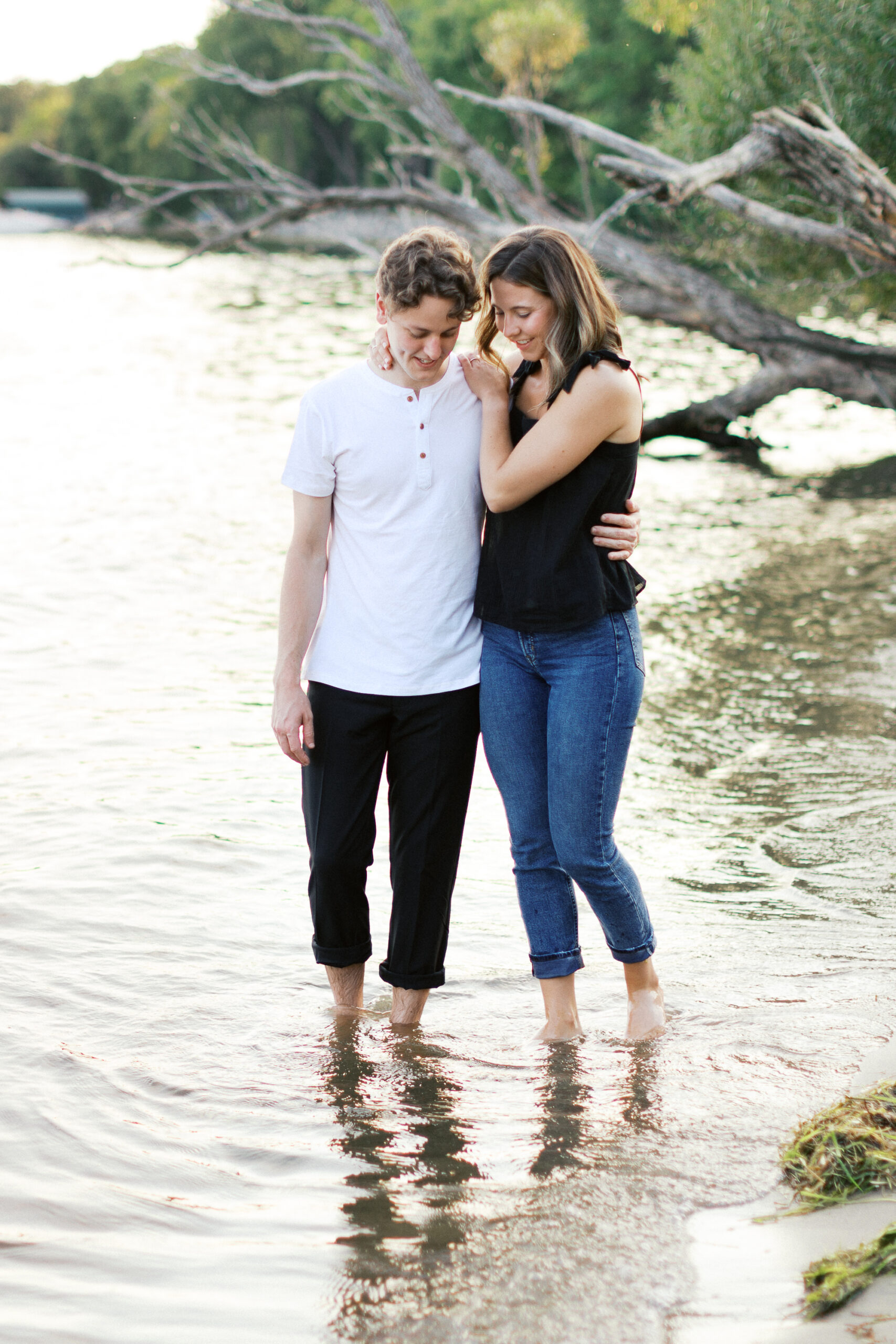 A tender moment as the couple walks together, wrapped in a warm embrace, gazing at the water in peaceful reflection. Captured by Toly Dzyuba Photography.