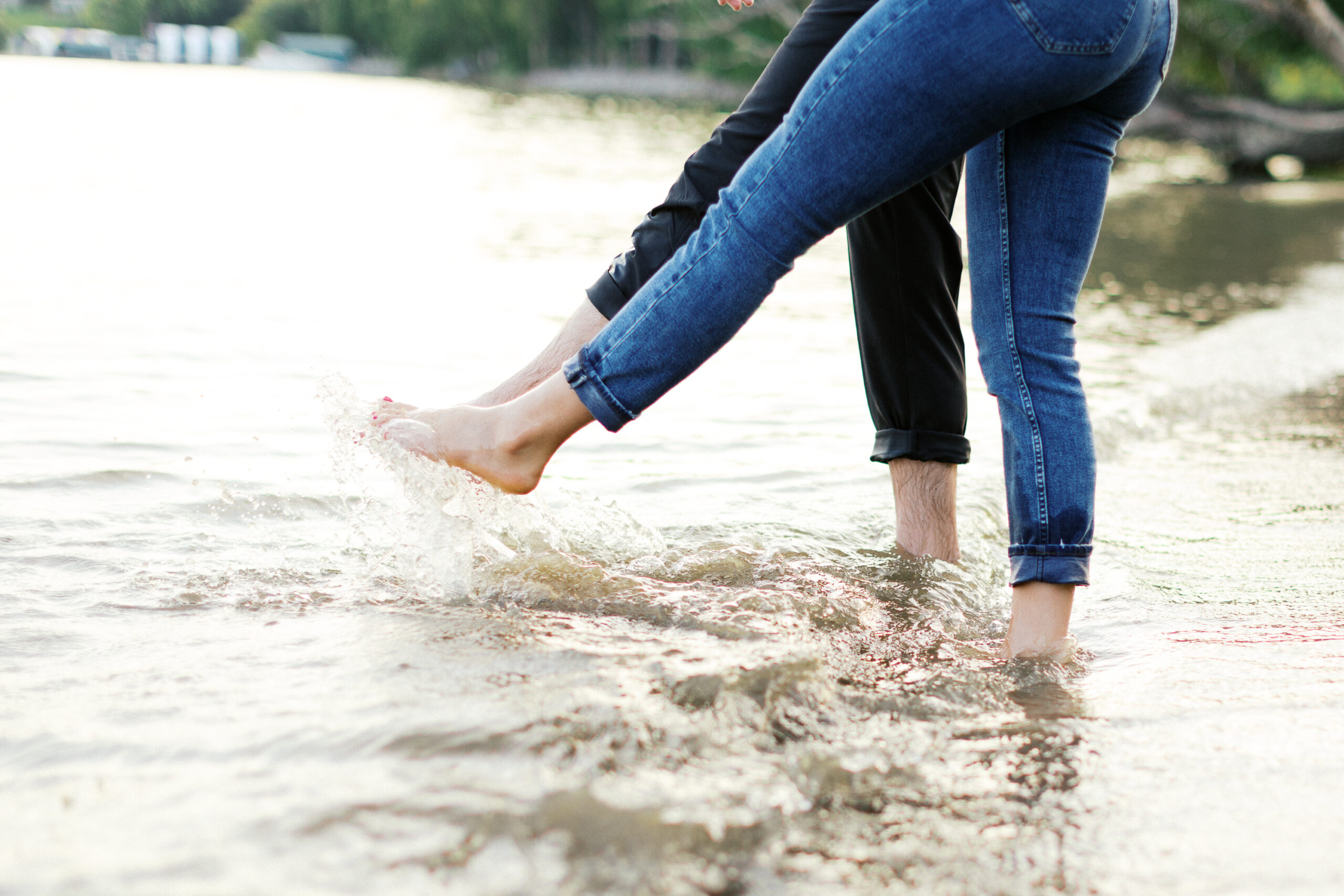 A playful and romantic moment as the couple splashes water with their feet. Captured by Toly Dzyuba Photography.