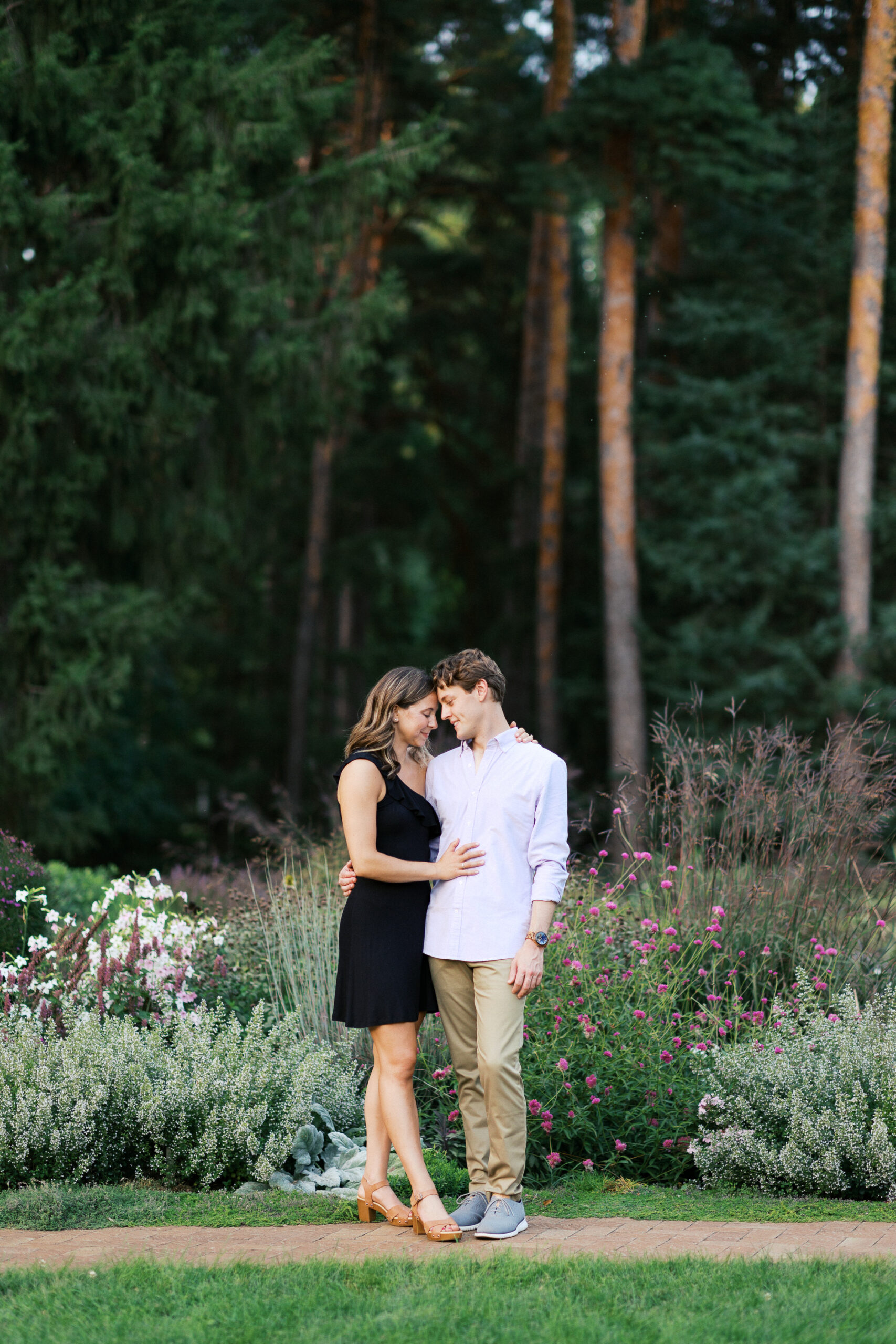 A romantic moment at Noerenberg Gardens in Orono—Matthew and Katherine touching heads together, surrounded by lush greenery. Captured by Toly Dzyuba Photography.