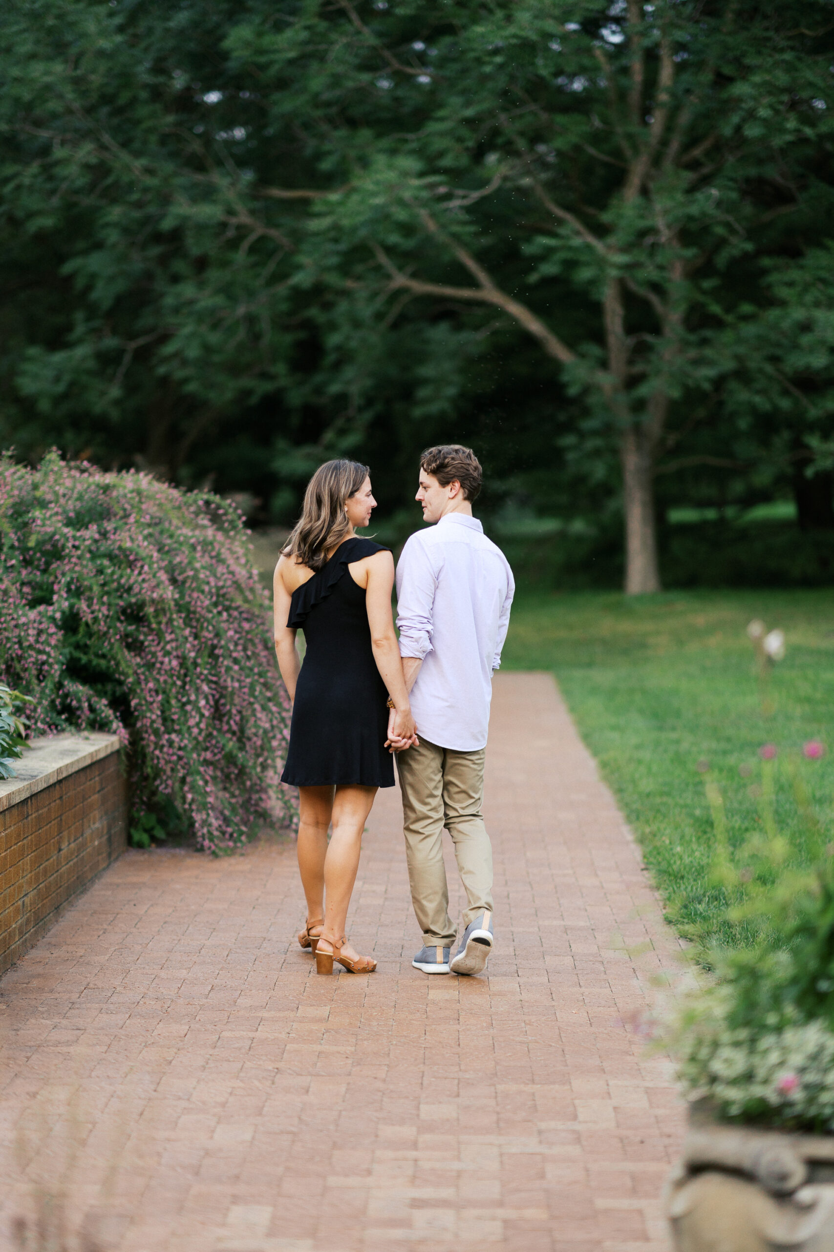 Couple holding hands and walking in the park of Wayzata.