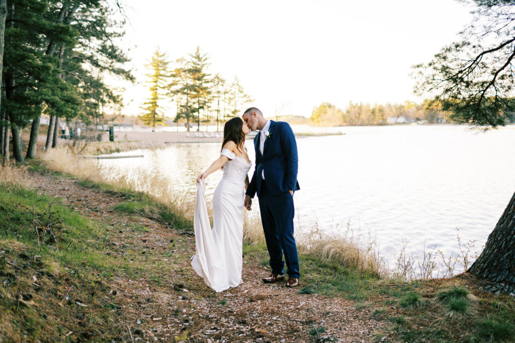 Newlyweds Jill & Anthony kiss as the sunset on the lake behind them at Catalyst by Nature Link event center.