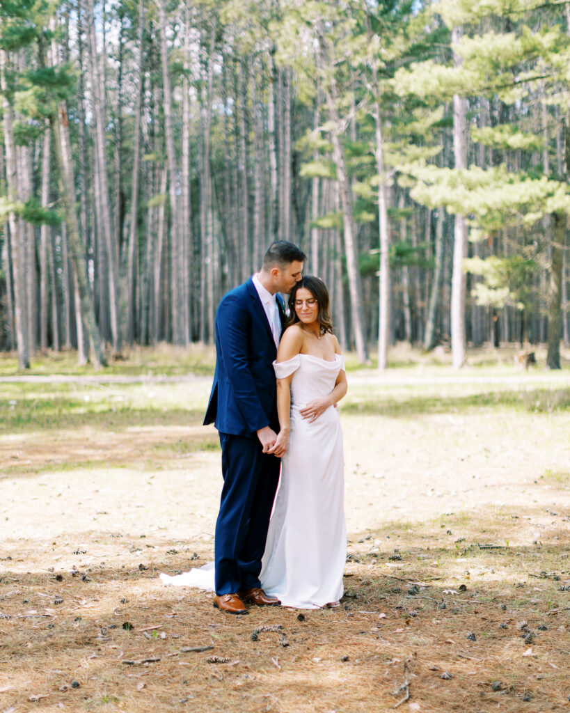 Groom kissing his bride in the head. Catalyst by nature link, photographed by Minnesota wedding photographer.