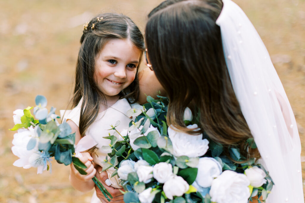 Flower girl is taking a picture with the bride