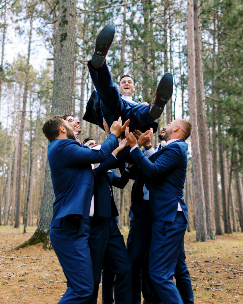 Groomsman in excitement toss the groom into the air. Catalyst by nature link.