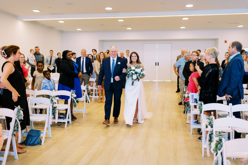 Father of the bride is walking her down the aisle.