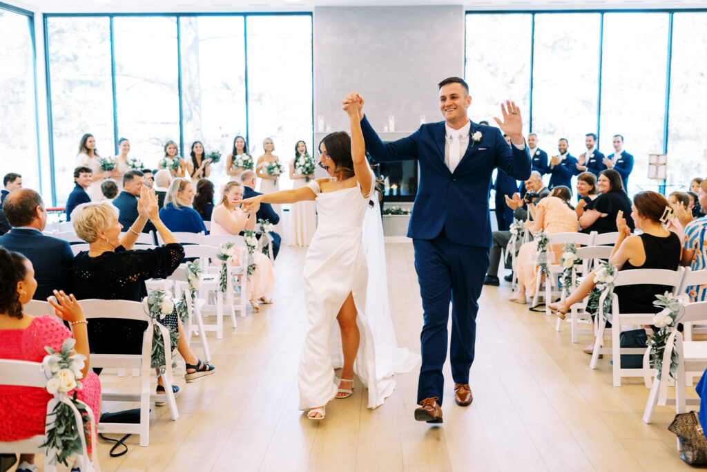 The bride and groom walking down the aisle as husband and wife with cheerful joy in the air.