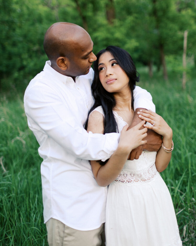 He gazes deeply into her eyes as he holds her over his shoulders, capturing a moment of love and connection.