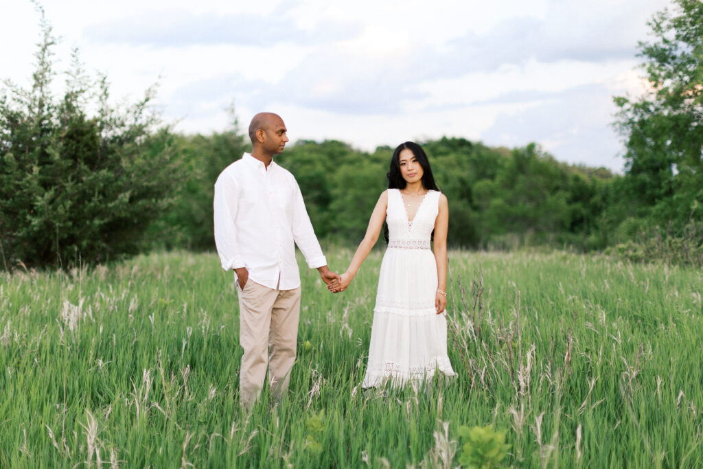 He gazes at her while she looks at the camera, standing in the tall grass at Elm Creek Park Reserve in Maple Grove.