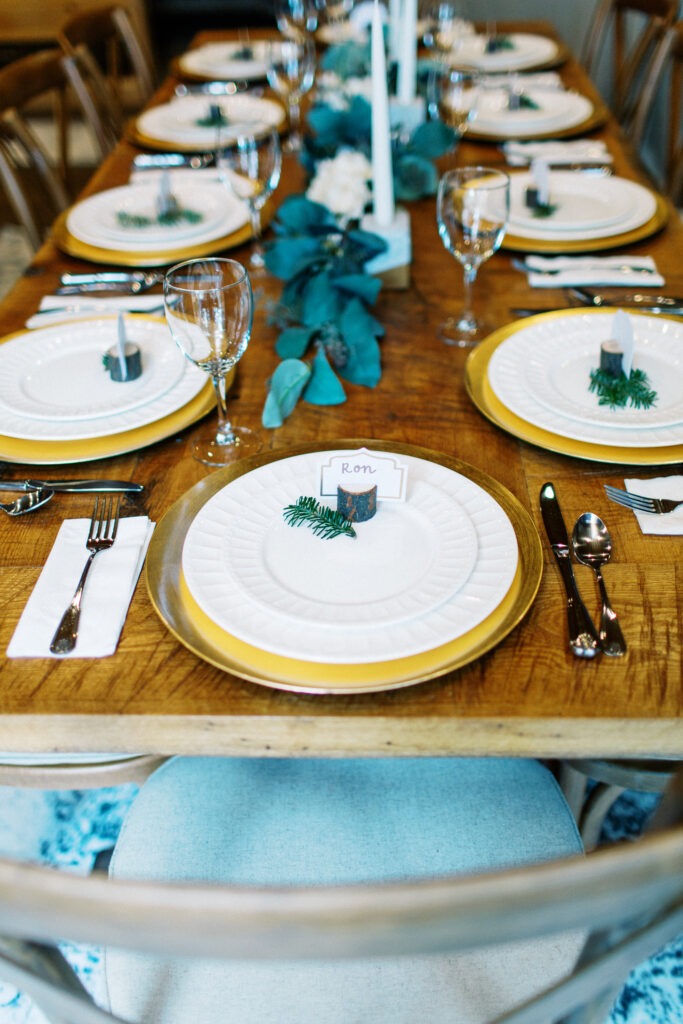 Details of plates and forks on the wedding day and a glass with small pine branches for decoration.