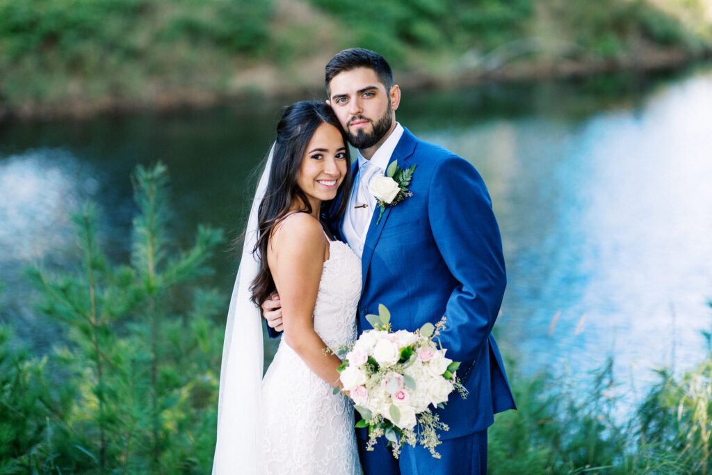 Bride and groom standing together posing for a photo with a smile. A true heartfelt Cabin Elopement in Webster, WI | Minnesota Wedding Photographer.