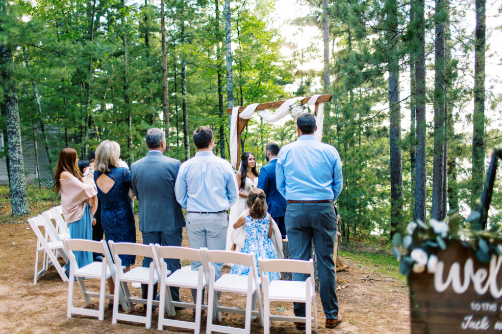Wedding ceremony surrounded by nature. Groom and bride stand at the altar. A true heartfelt Cabin Elopement in Webster, WI | Minnesota Wedding Photographer.
