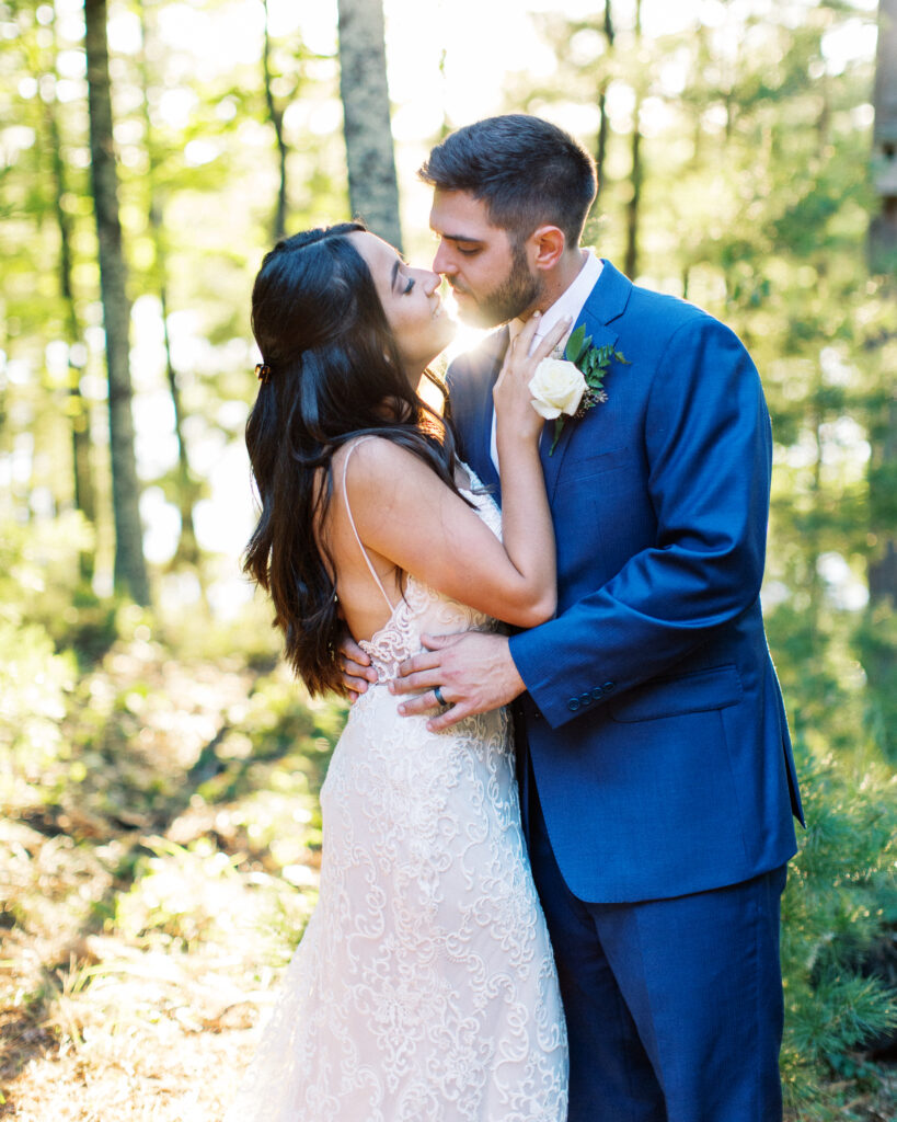 Bride and groom looking at each other with joy in the close position as they shower in the golden sunset light. This scene occurred during a heartwarming cabin elopement in Webster, WI captured by a Minnesota Wedding Photographer.