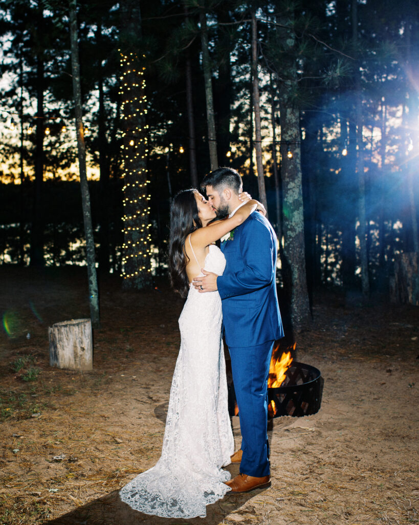 By the bonfire newlyweds stand and kiss. A true heartfelt Cabin Elopement in Webster, WI | Minnesota Wedding Photographer.