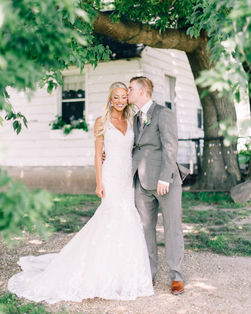 Groom kisses his bride as she closes her eyes, at Legacy Hill Farm.
