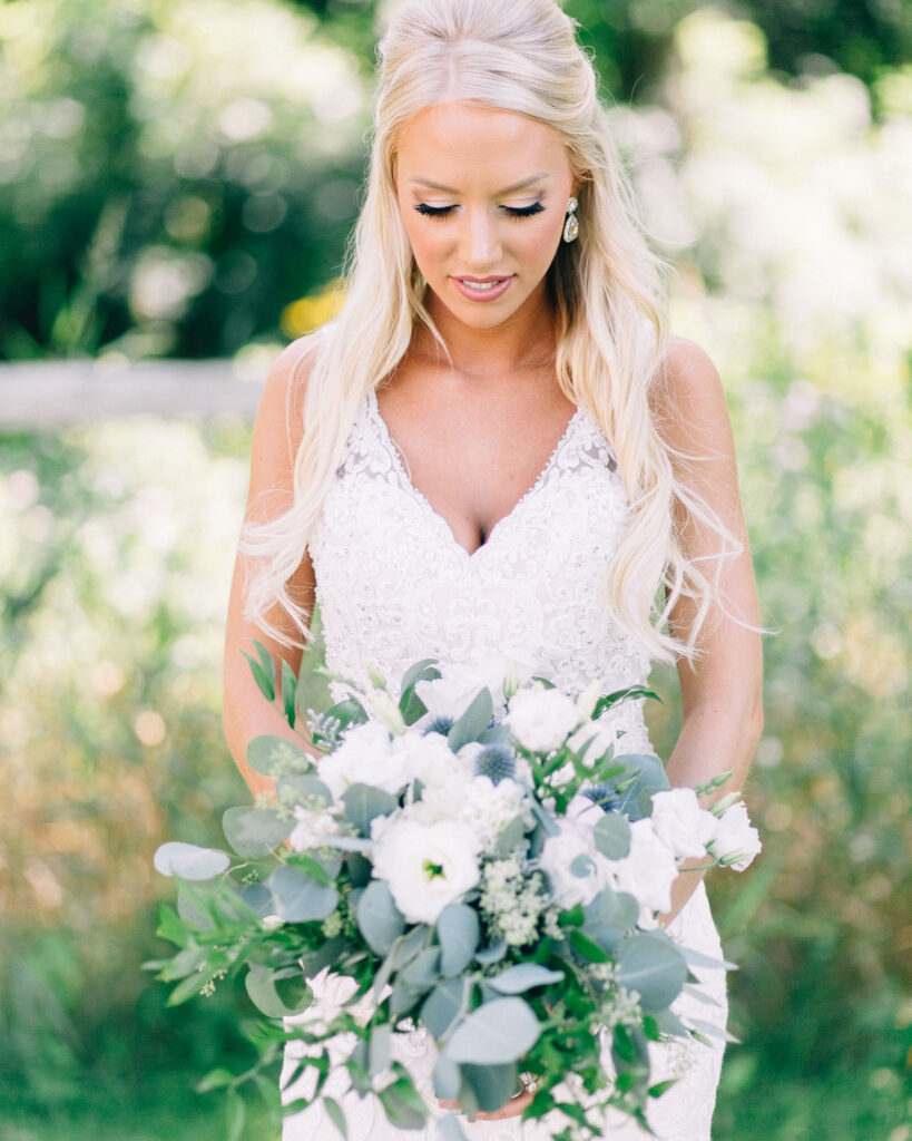 brides looks at her wedding bouquet.