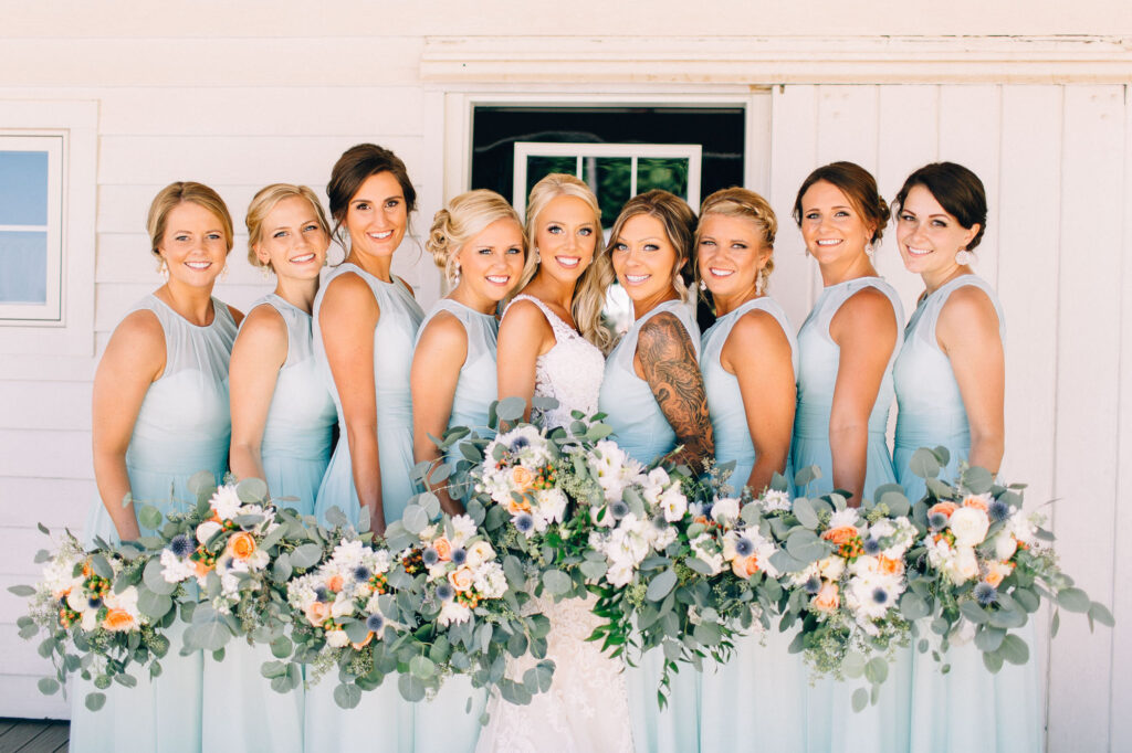 Bridesmaids standing together and smiling with their beautiful bouquets at Legacy Hill Farm.